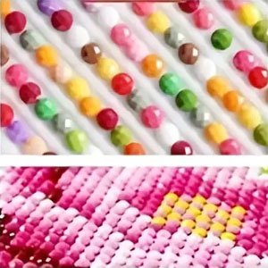 Close-up of colorful round diamond painting beads and a partially completed pink floral pattern.