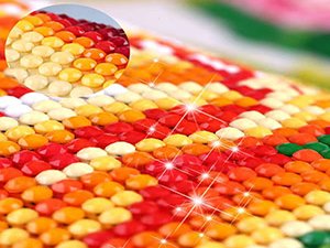 Close-up of colorful round diamond painting beads with a magnified inset showing detail.