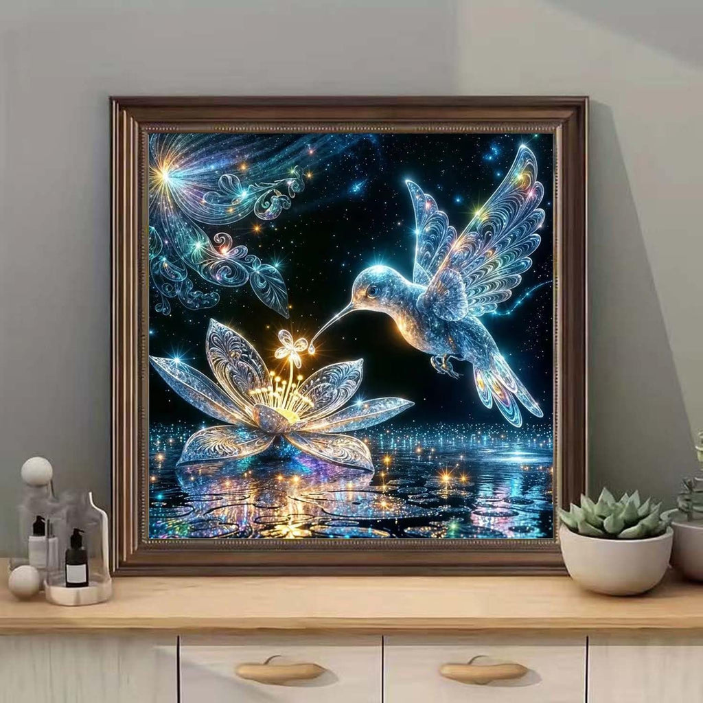 Diamond painting kit featuring a luminous hummingbird hovering over a glowing lotus flower with reflections on water.