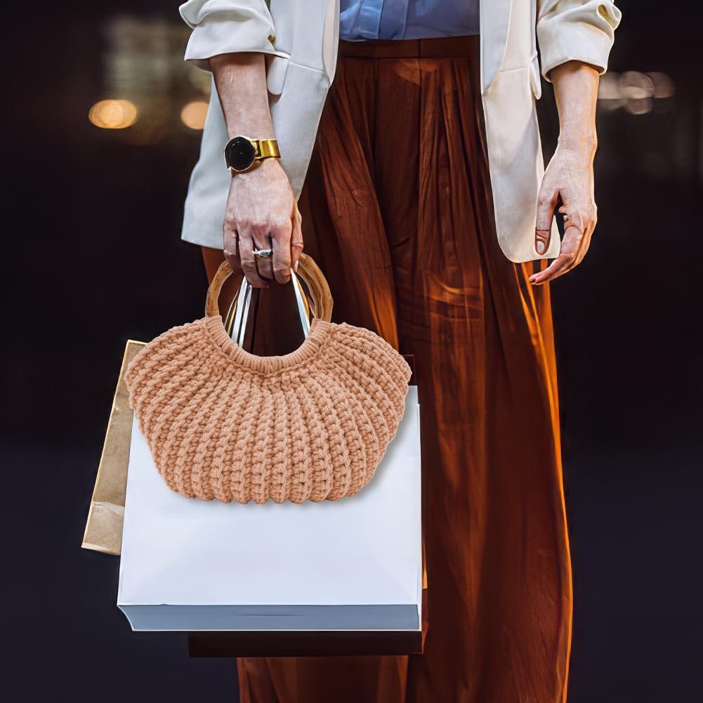 Person holding a crochet tote bag with wooden handles and shopping bags
