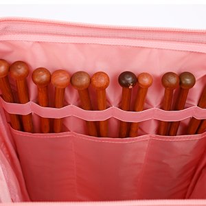 Pink knitting crochet backpack interior showing multiple wooden knitting needles stored in elasticated pockets.