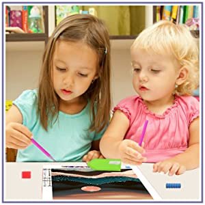 Two young girls doing a diamond painting kit at a table, with the canvas and tools visible.