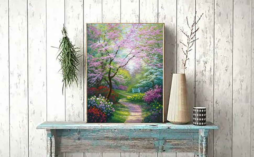 Diamond painting kit showing a winding path through a garden with blooming pink trees and colorful flowers, a white bench visible in the distance.