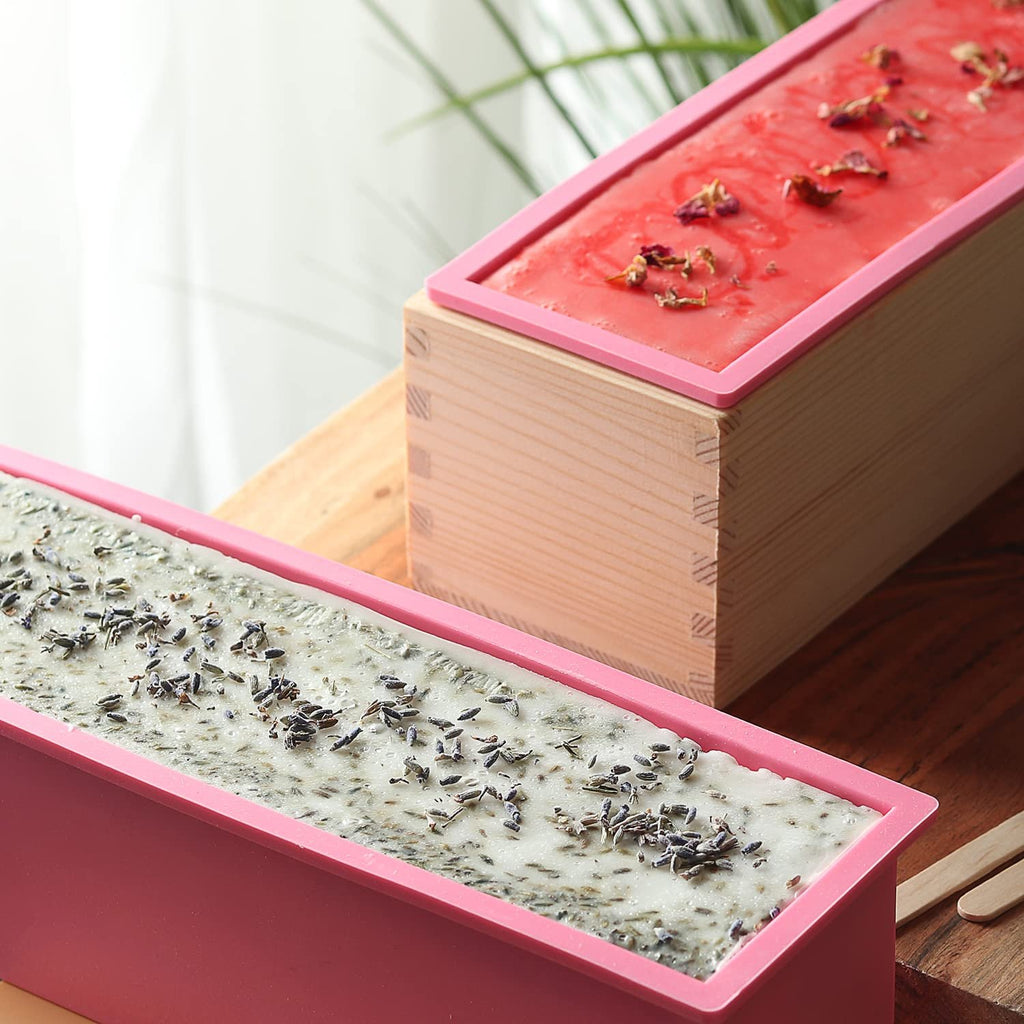 Two soap molds with soap bases, one with lavender buds and the other with rose petals.