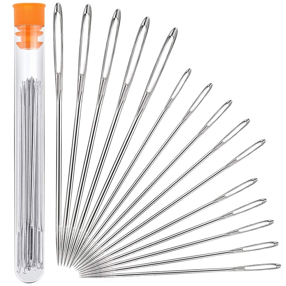 Set of 15 large eye sewing needles in varying sizes with a clear storage bottle and orange cap, fanned out on a white background.