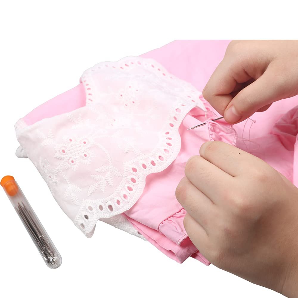 Hands sewing a pink garment with white lace trim, storage bottle of needles nearby