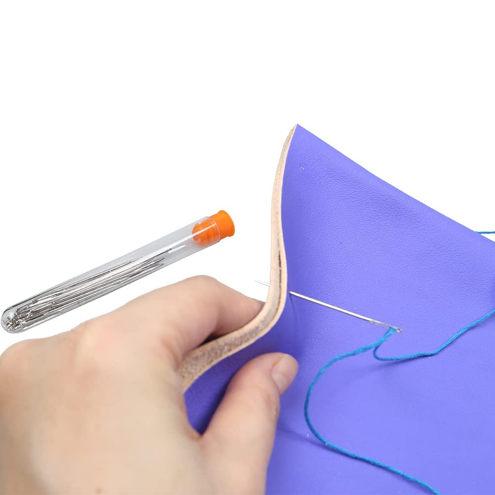 Hand holding a tube of large eye sewing needles and stitching purple leather with a needle and blue thread
