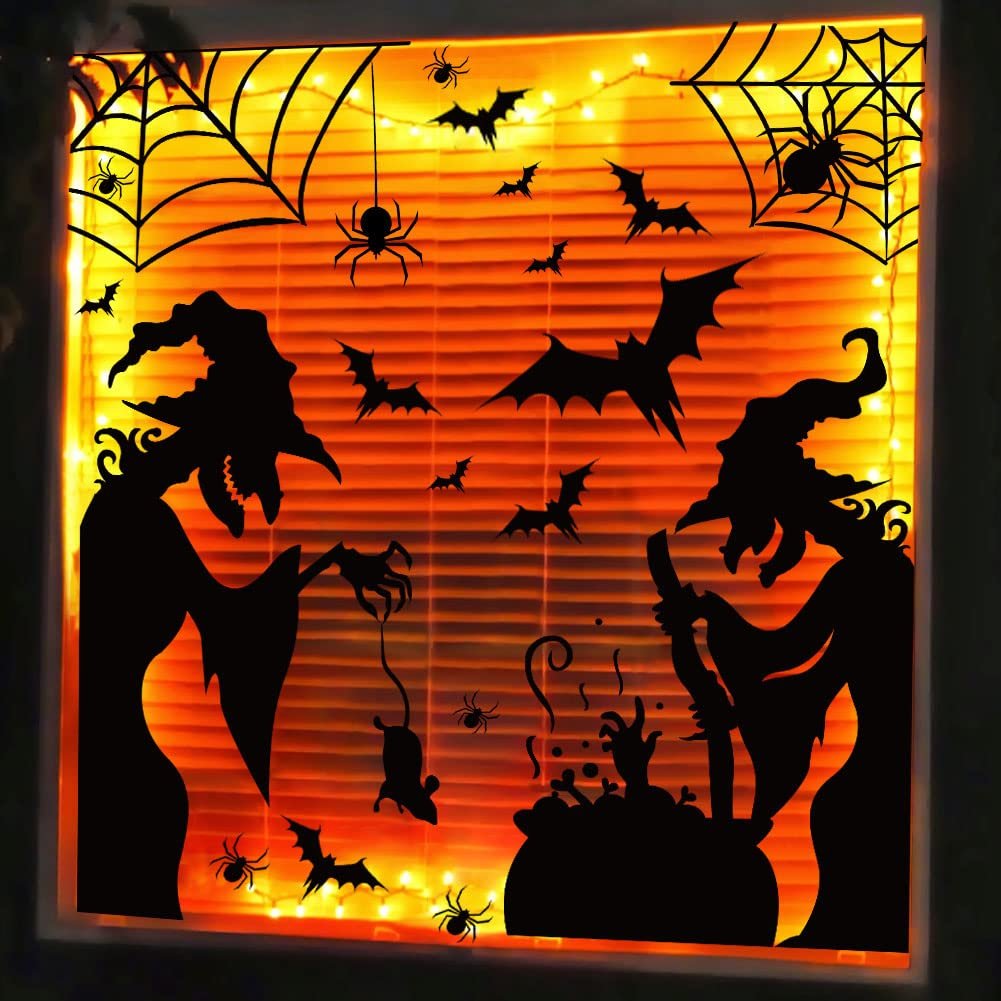 Halloween window clings featuring witches, bats, spiders, and webs against orange blinds with fairy lights.