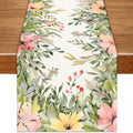 Linen table runner with watercolor floral and leaf border on a wooden table