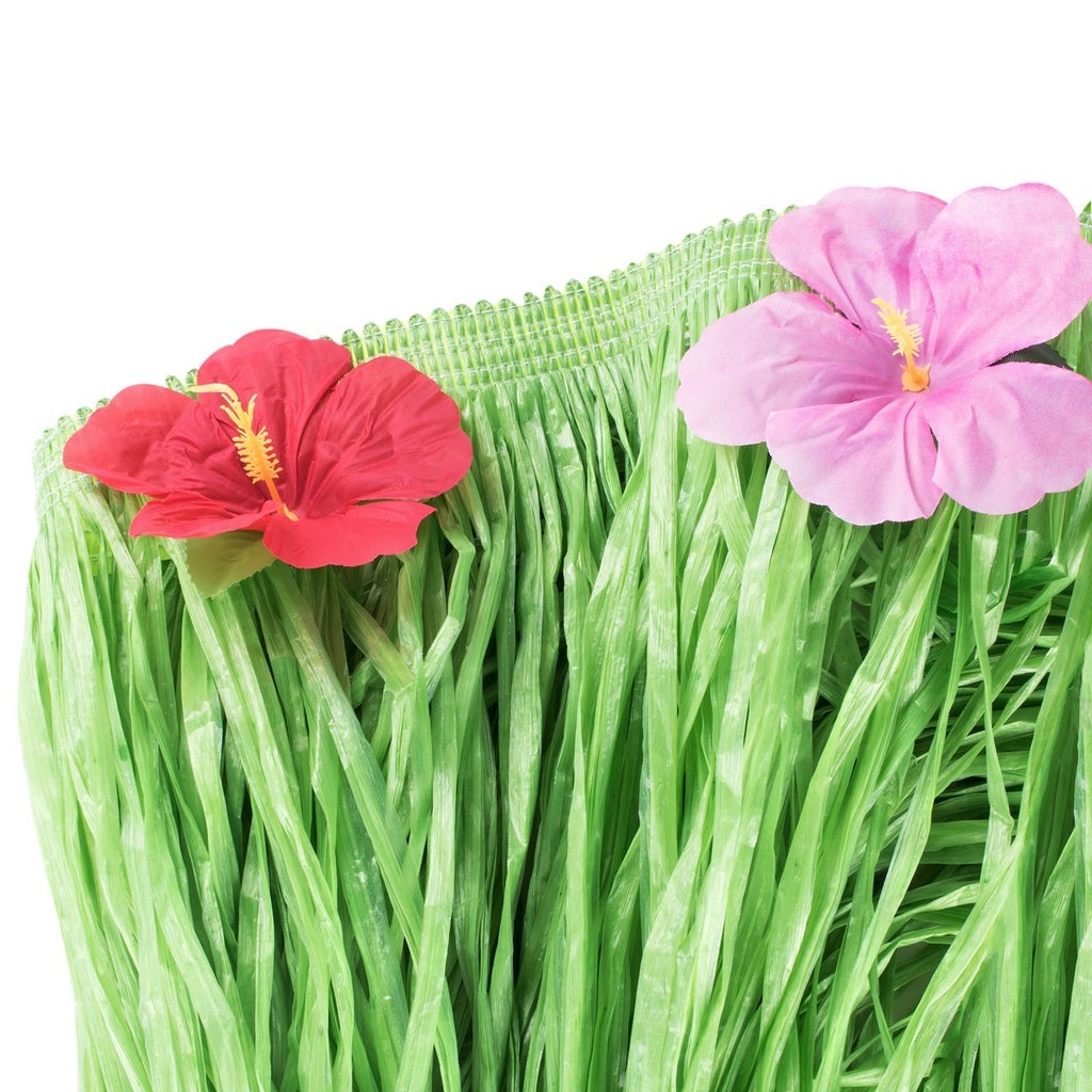 Green luau grass table skirt with red and pink hibiscus flowers, close-up detail.
