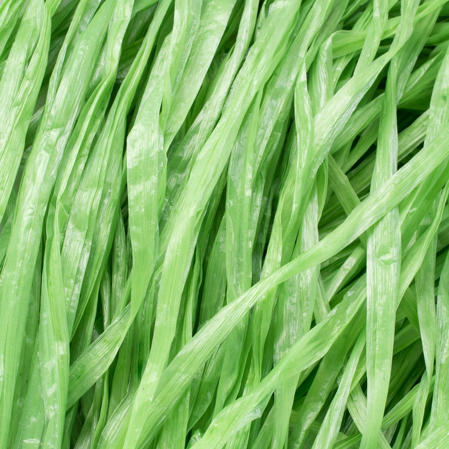 Close-up of green luau grass table skirt material, showing textured plastic strands.