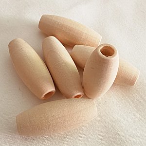 Several oval-shaped natural wood beads scattered on a light fabric surface.