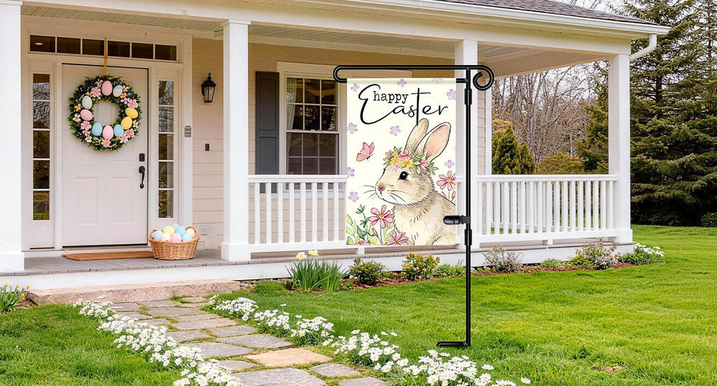 Black metal garden flag stand with a decorative Easter flag featuring a bunny and flowers, displayed on a porch.