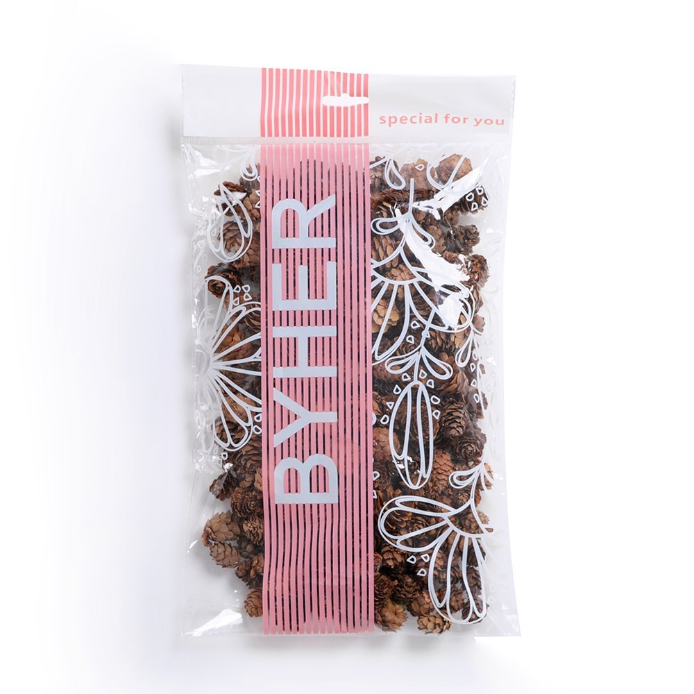 Bag of small natural pine cones with decorative floral pattern and pink stripe.