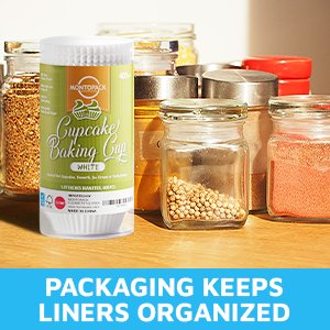 Roll of white cupcake liners with green and orange label, surrounded by jars of spices.
