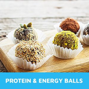 Assortment of five protein and energy balls in white paper liners on a wooden board.