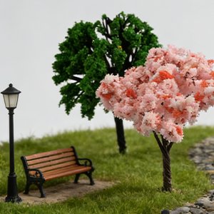 Miniature park scene with a bench, lamppost, and two artificial trees, one green and one pink cherry blossom.