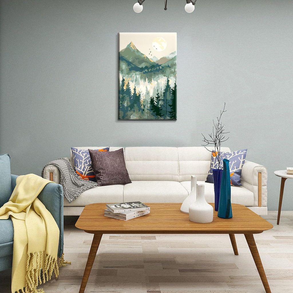 Framed mountain landscape paint by number artwork hanging on a wall above a sofa