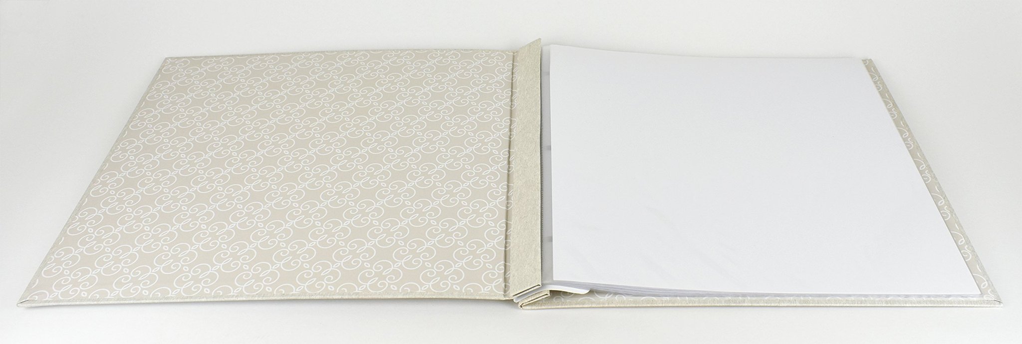 Open ivory post-bound scrapbook album with decorative pattern on the left cover and blank pages on the right.