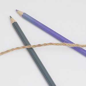 Natural jute twine with two colored pencils on a white background