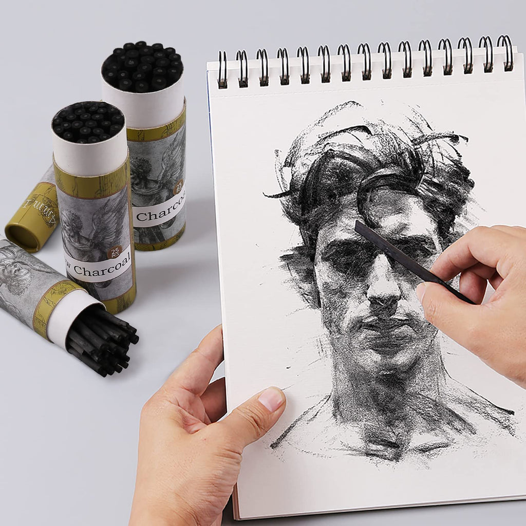 Artist's hands sketching a portrait with charcoal sticks and a sketchbook, with charcoal stick containers in the background.