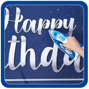 Close-up of a hand ironing a navy blue banner with white 'Happy Birthday' text.