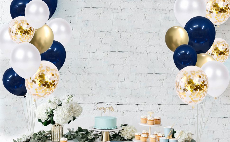 Navy blue, pearl white, and gold confetti balloons arranged around a cake and cupcakes on a table.