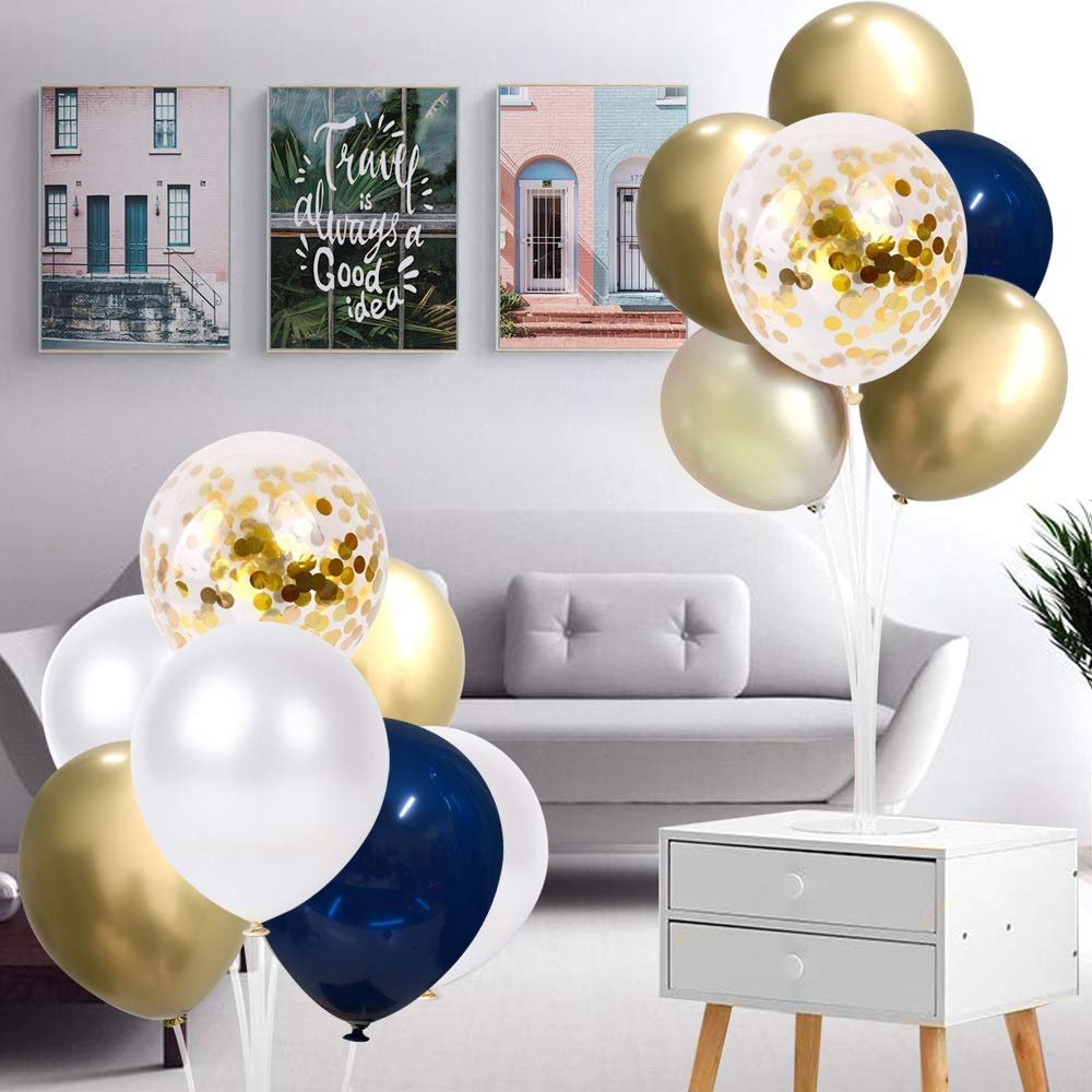 A display of navy blue, pearl white, and gold confetti balloons arranged on a stand in a living room setting.