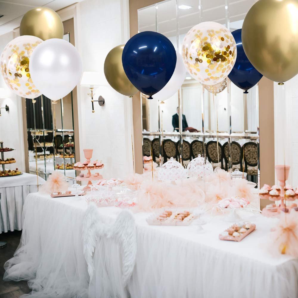 Navy blue, pearl white, gold, and confetti balloons floating above a decorated party table with desserts.