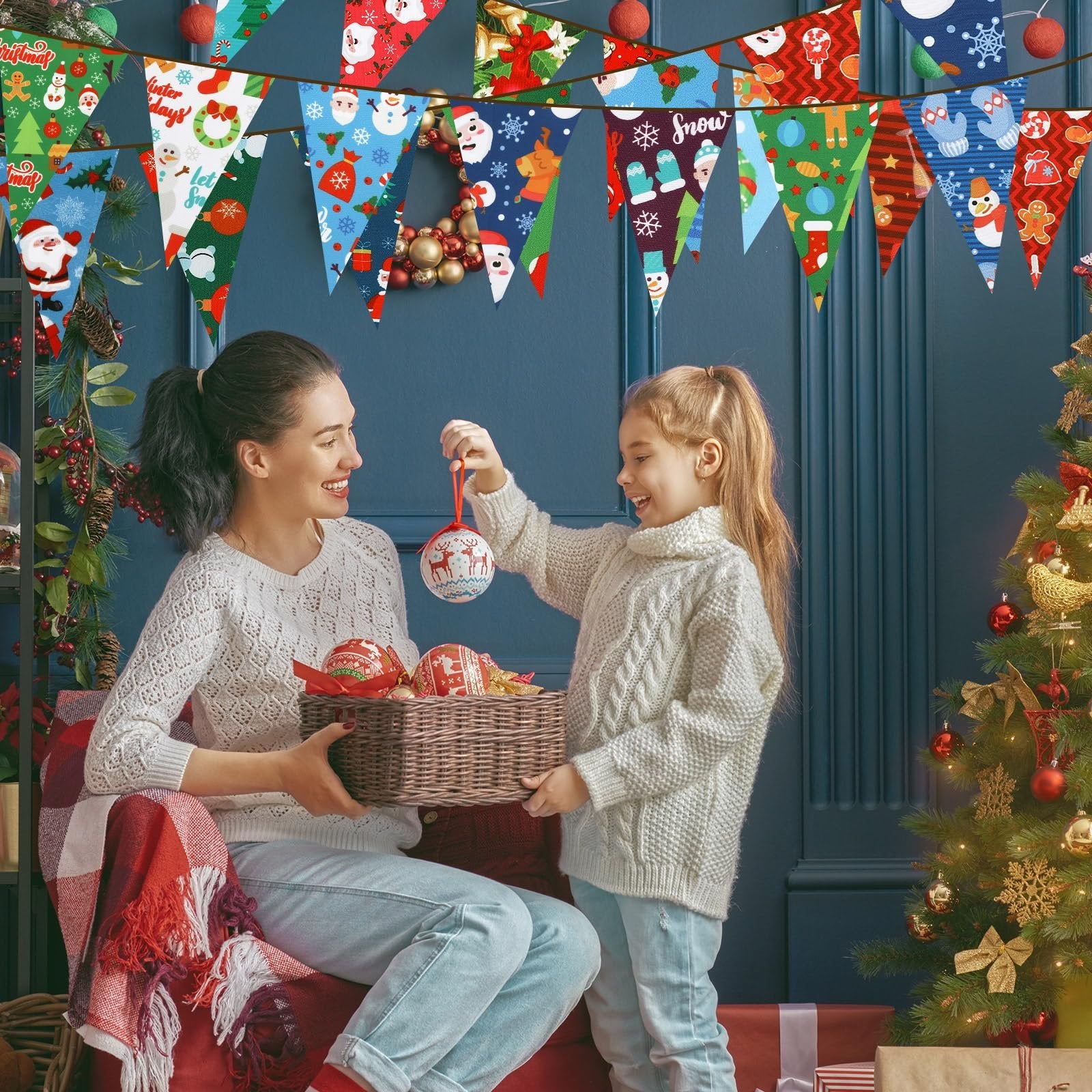 Mother and daughter decorating a Christmas tree with ornaments and festive bunting