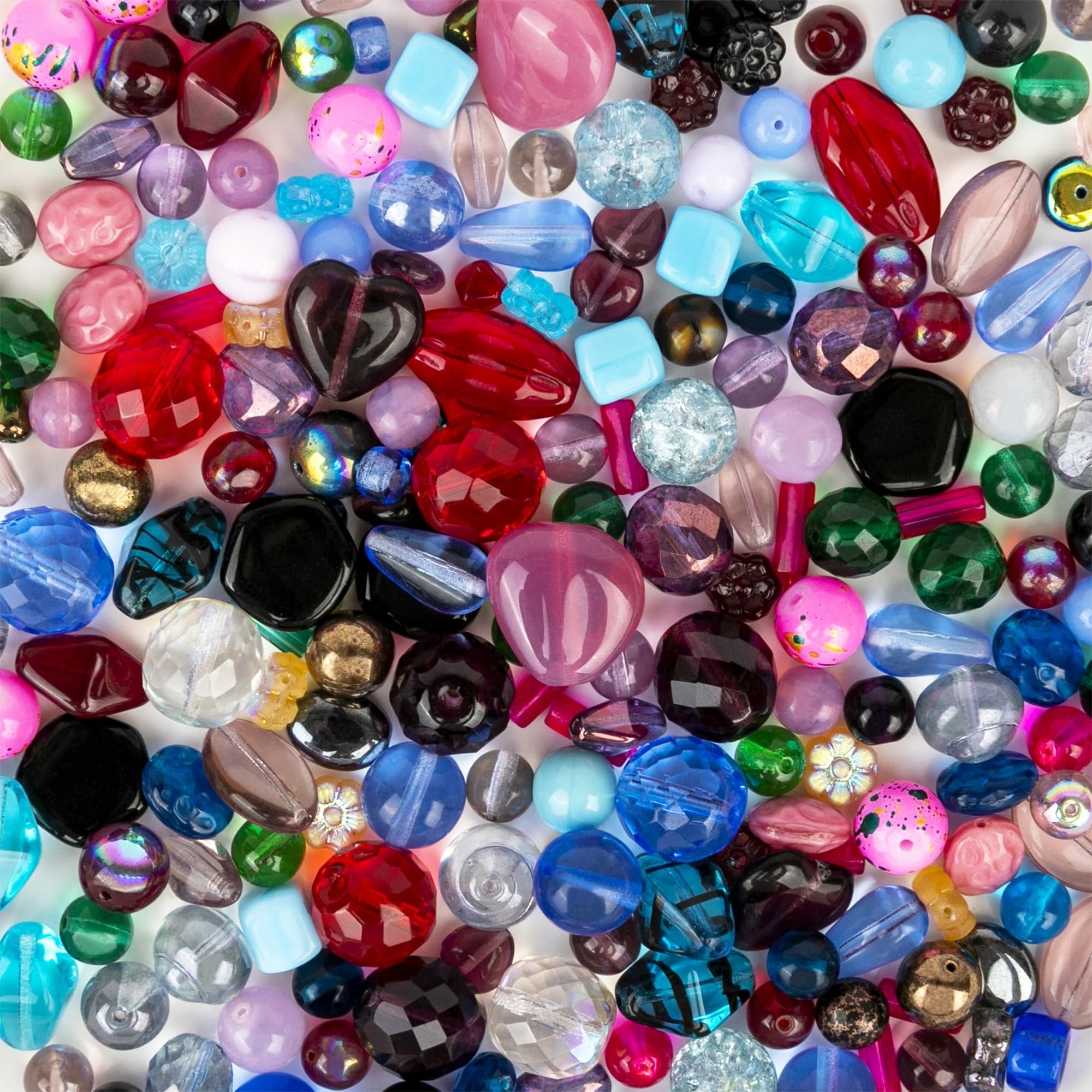Assorted glass beads in various shapes, sizes, and colors, including red, blue, pink, and clear, scattered on a white background.