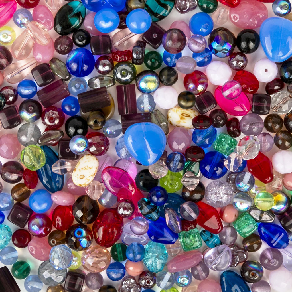 Assorted glass beads in various shapes, sizes, and colors, including blue, pink, red, green, and clear, for jewelry making.