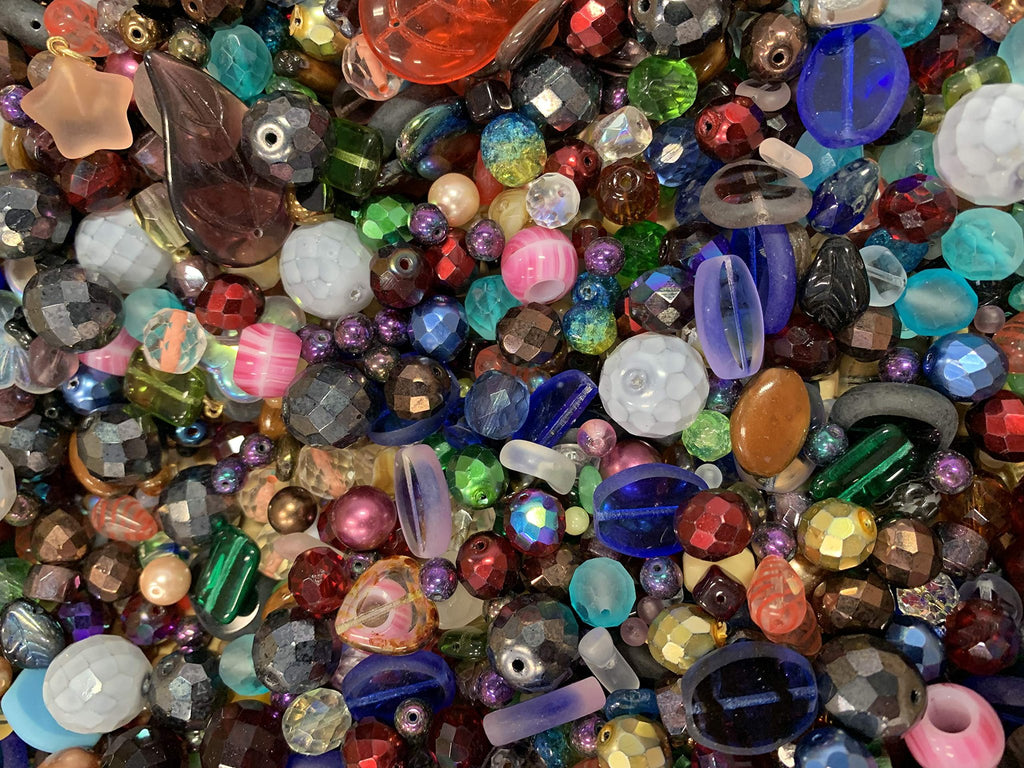 Assorted glass beads in various shapes, sizes, and colors, including star, leaf, and faceted round beads, for jewelry making.