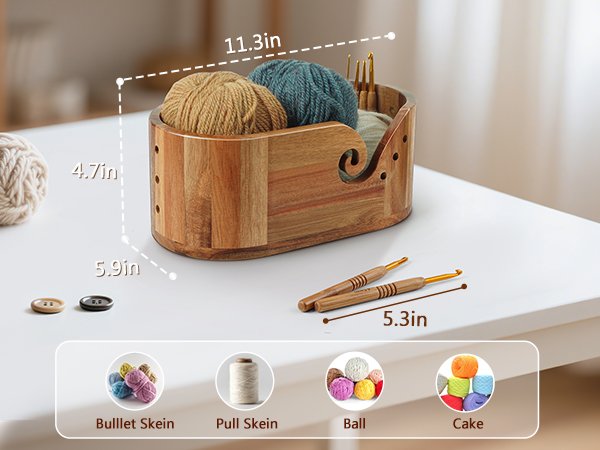 Oval acacia wood yarn bowl filled with yarn skeins and crochet hooks, with dimensions indicated.