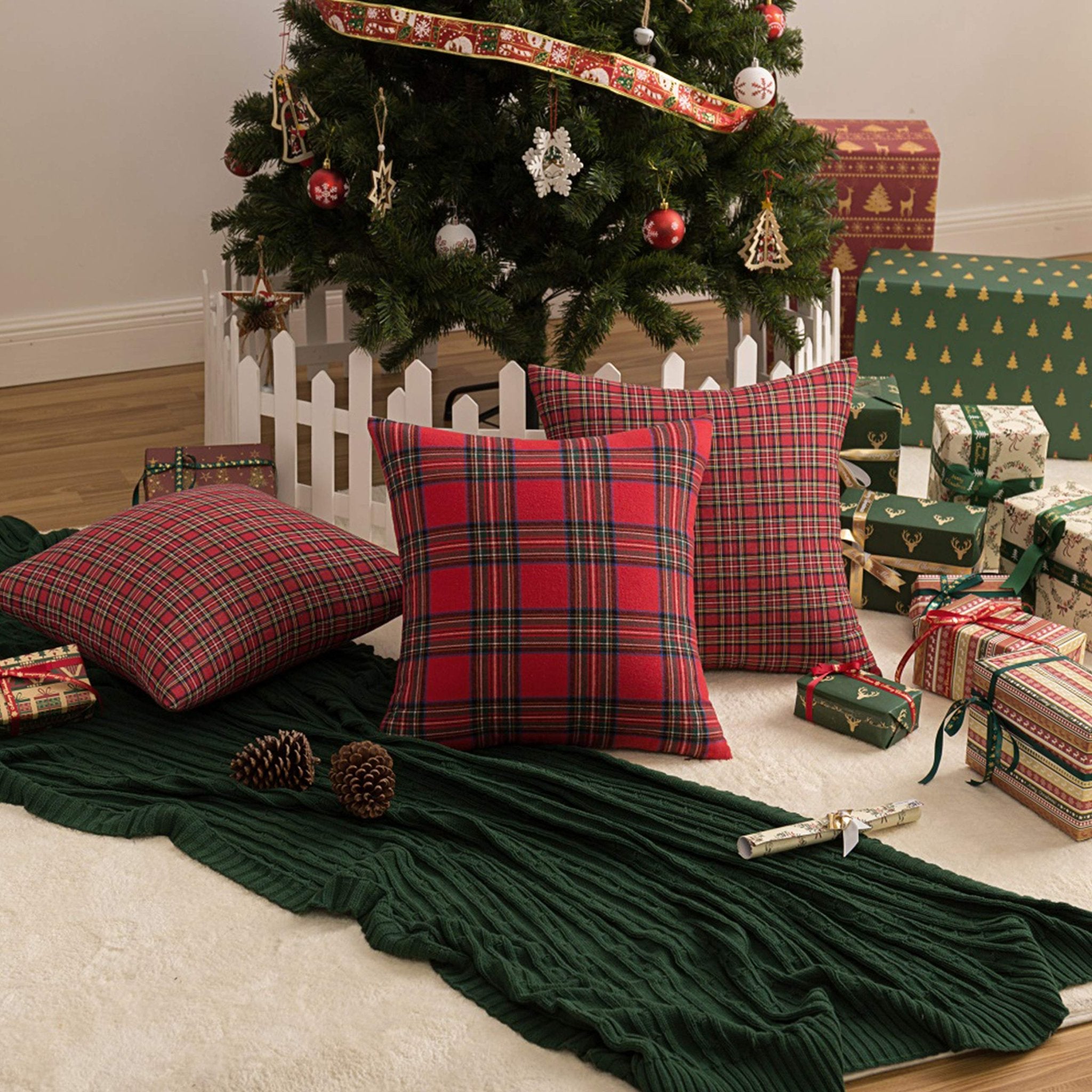 Christmas tree with plaid throw pillows and gifts on a rug