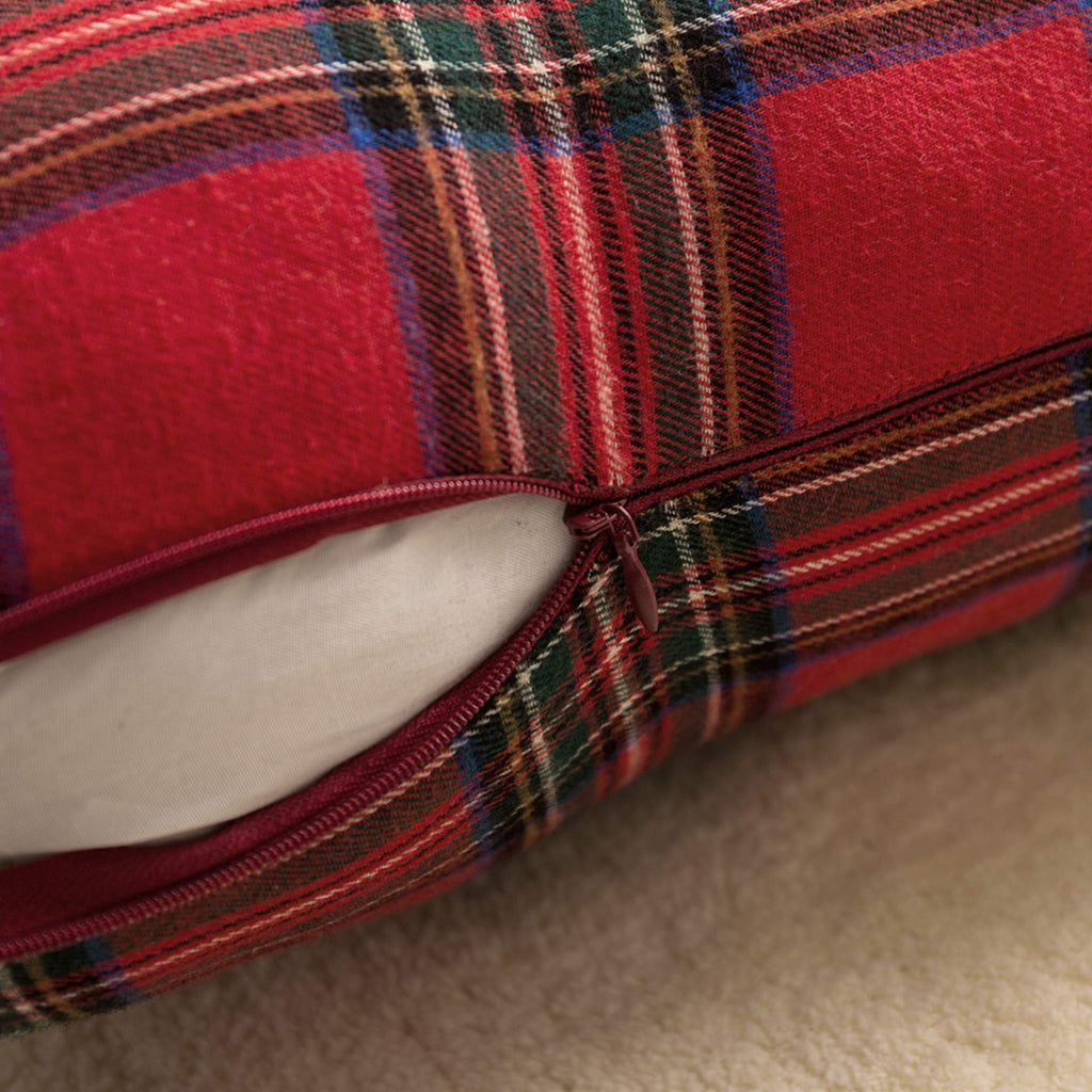 Close-up of a red and green plaid Christmas throw pillow cover with a visible zipper.
