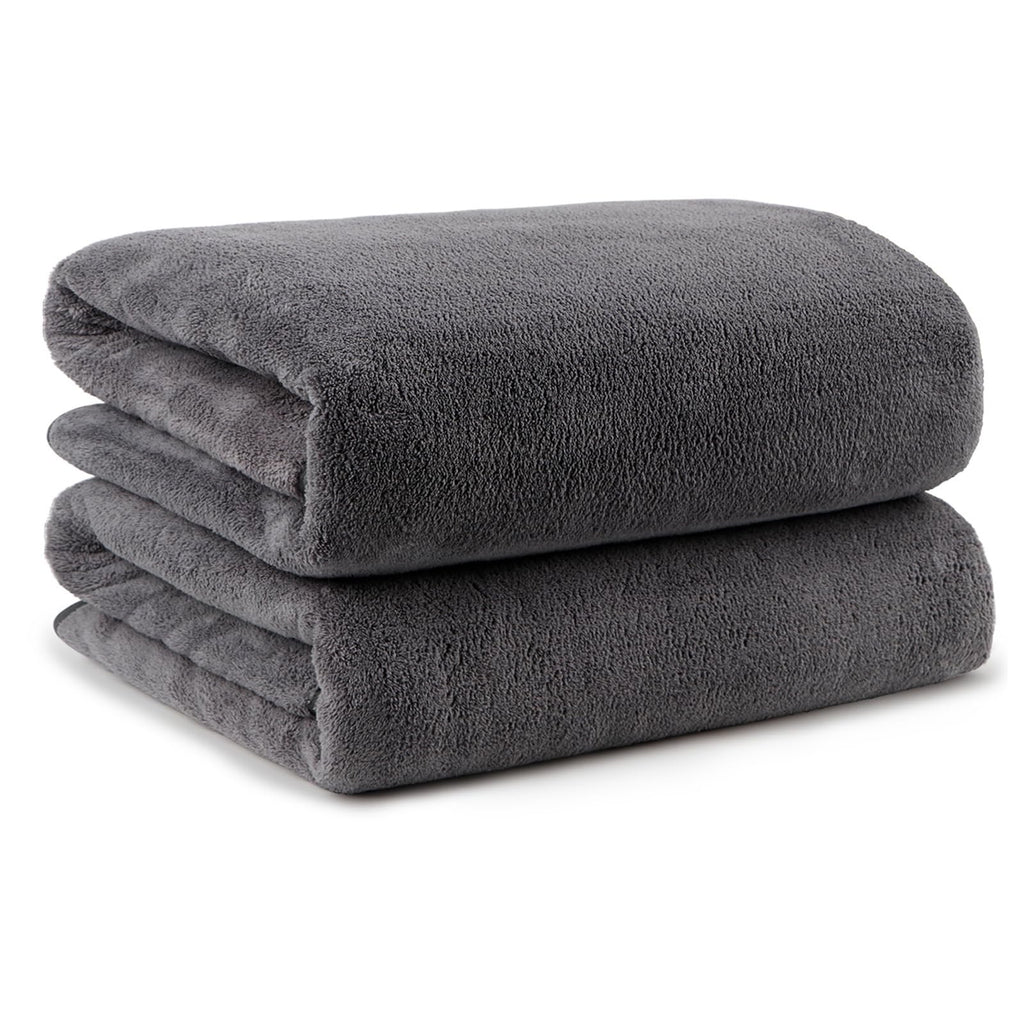 Two folded grey microfiber bath towels stacked on a white background.