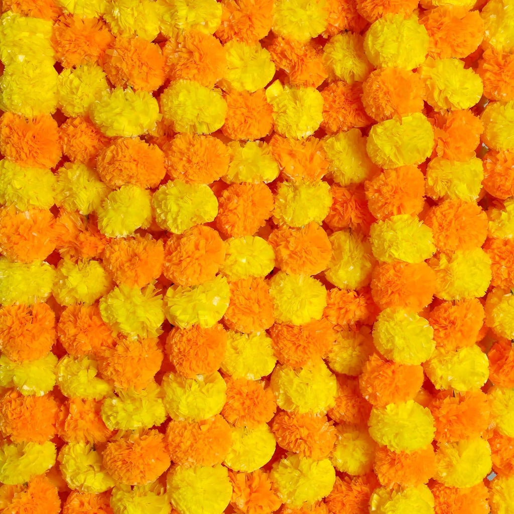 Close-up of orange and yellow artificial marigold flower garlands, densely packed.