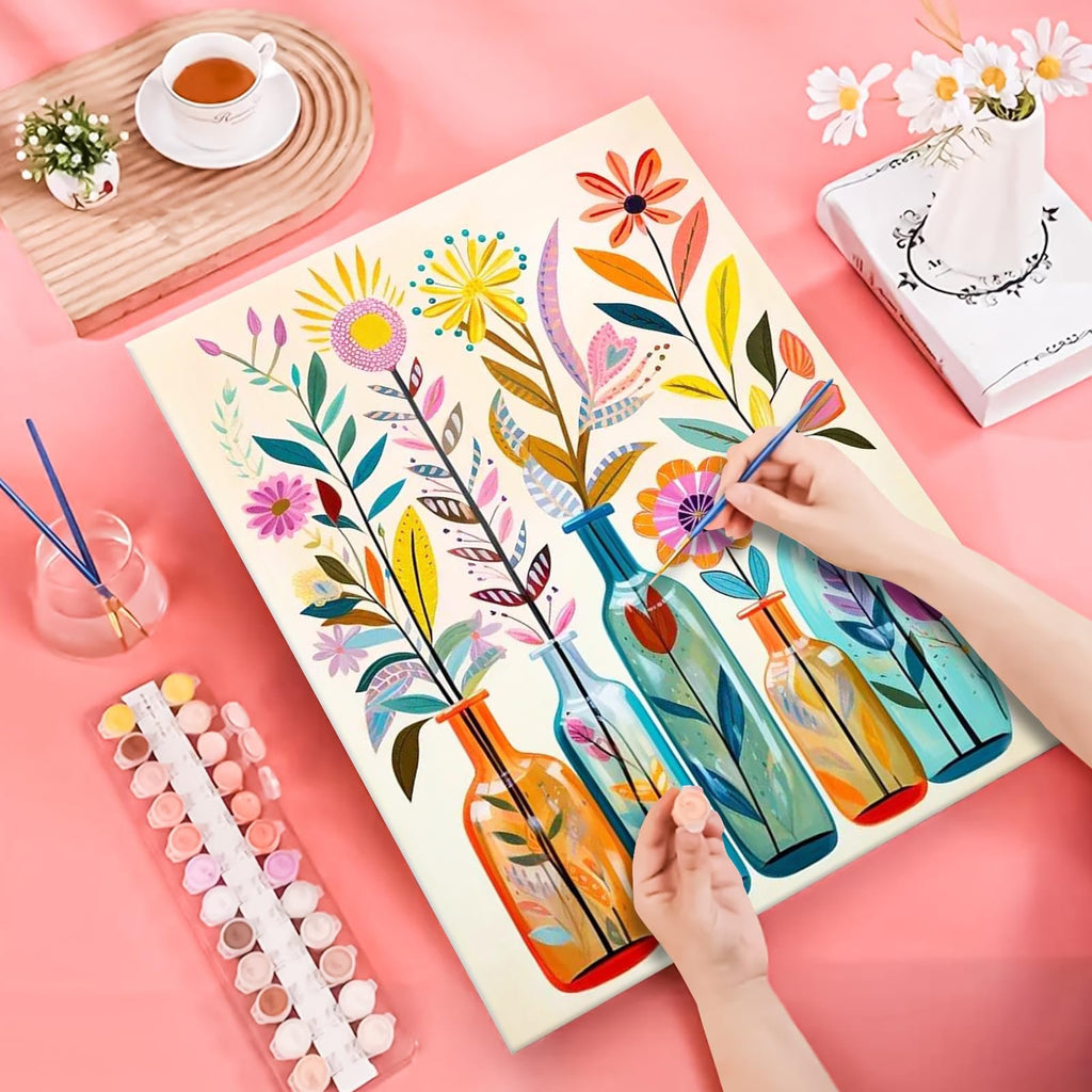 Paint by Numbers canvas showing colorful flowers in vases, with hands holding brushes and paint pots.