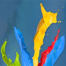 Splashes of yellow, blue, red, and green paint against a blue background.