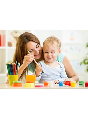 Woman and child painting together at a table with art supplies including pencils and paints.
