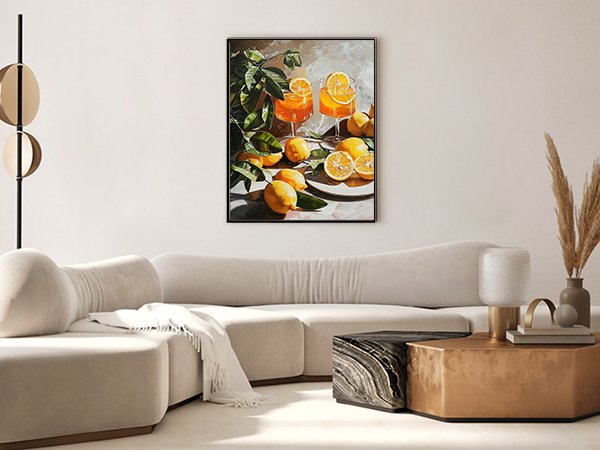 Painting of oranges and orange juice glasses hanging on a wall above a sofa