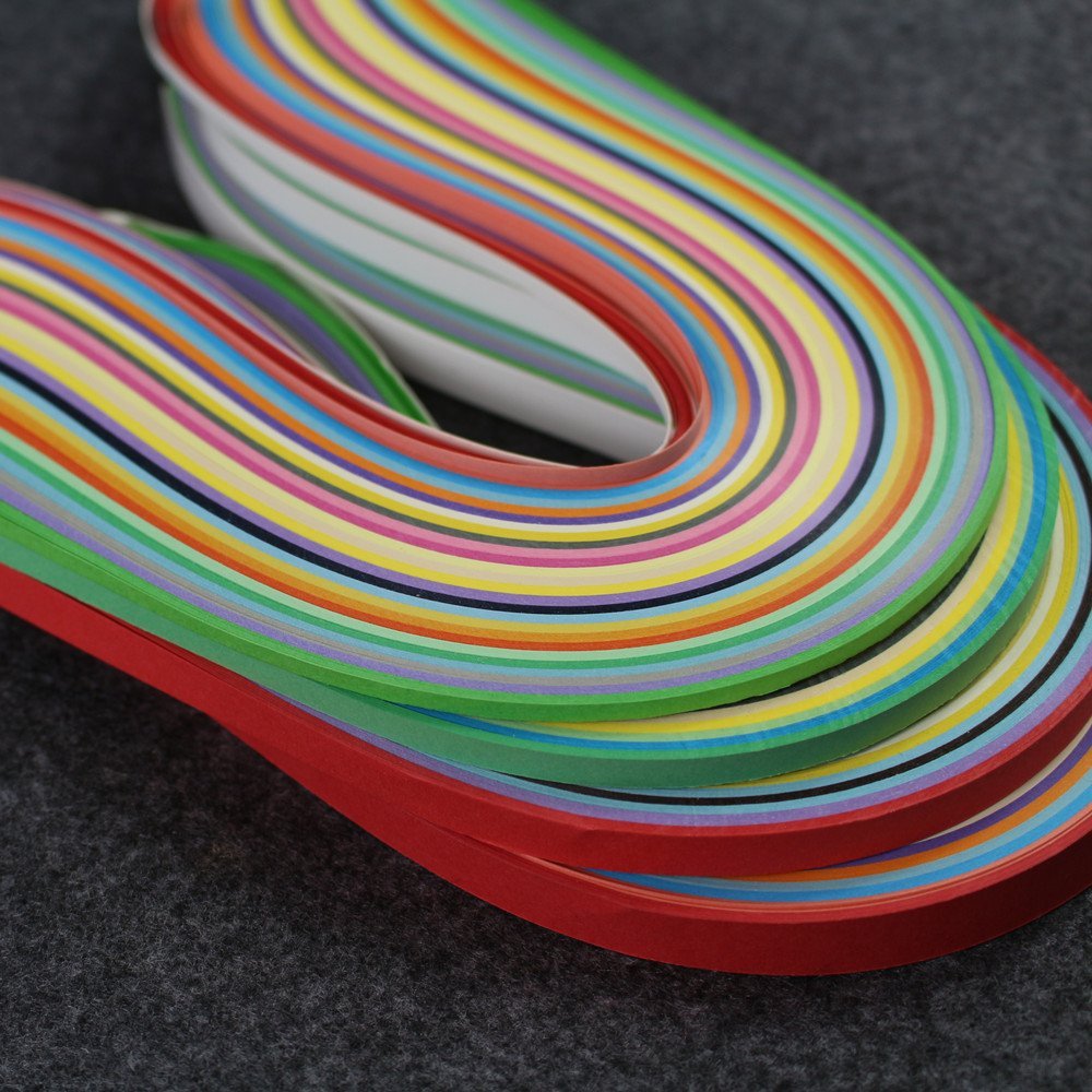 Close-up of colorful paper quilling strips in various widths and colors, arranged in curves on a dark textured surface.