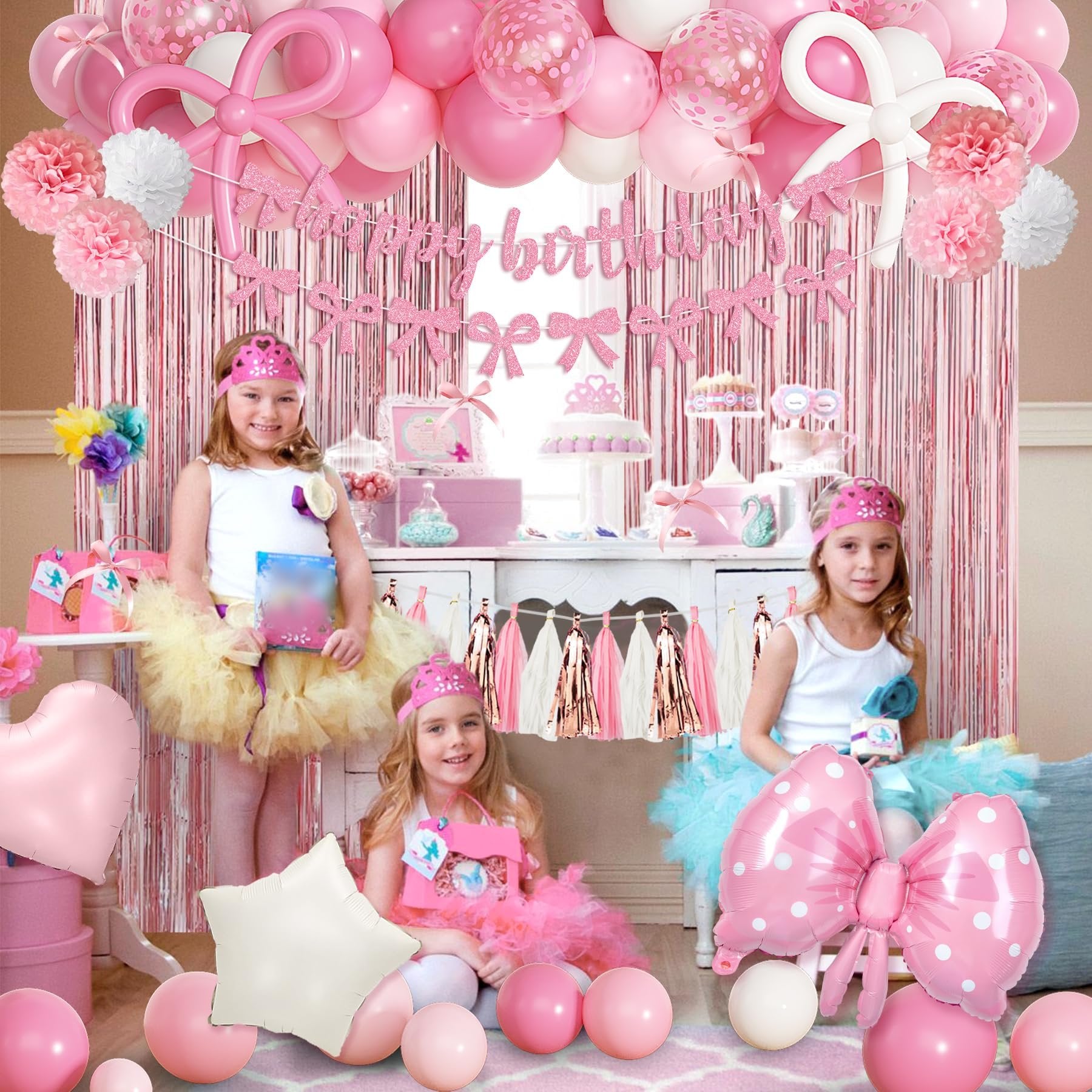 Pink birthday party decorations with girls in tutus, balloons, banner, and fringe curtain.