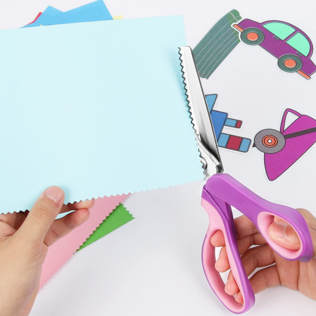 Pinking shears with purple handles cutting a light blue piece of paper, showing zig-zag edges on paper scraps and cartoon car cutouts.