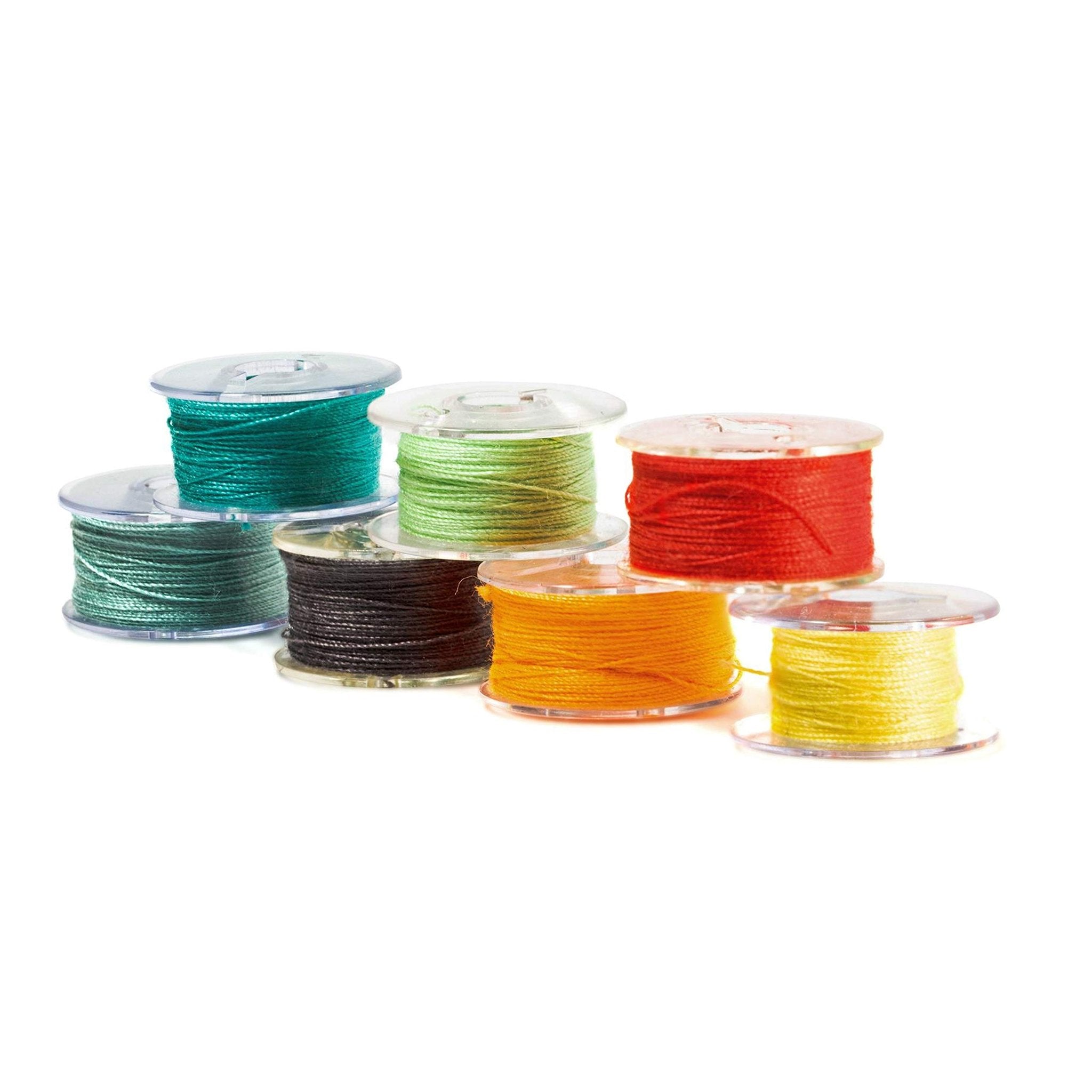 Assorted colored sewing machine bobbins with thread, arranged in a staggered pattern on a white background.