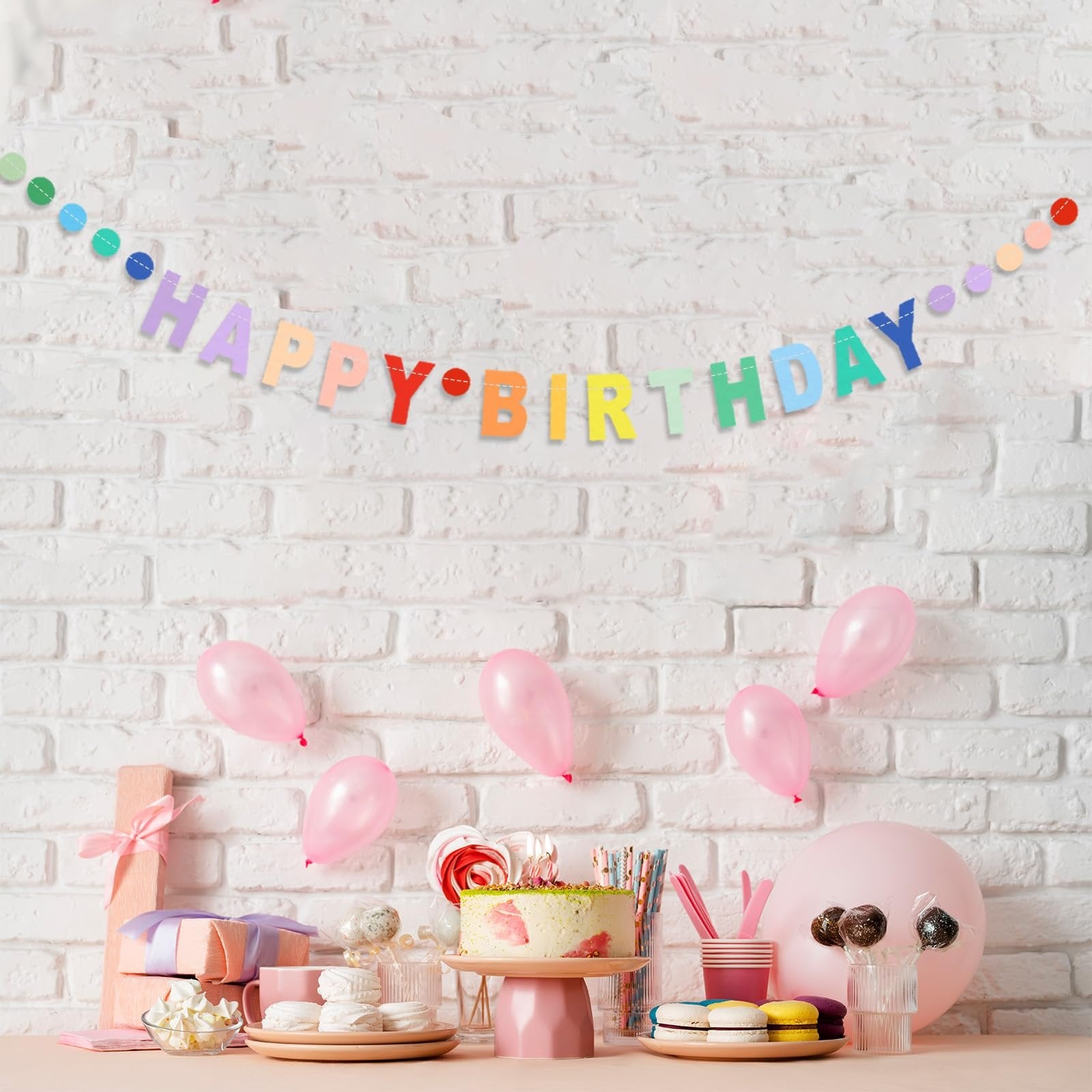 Happy Birthday banner with rainbow letters and colorful dots, displayed with pink balloons, cake, and gifts.