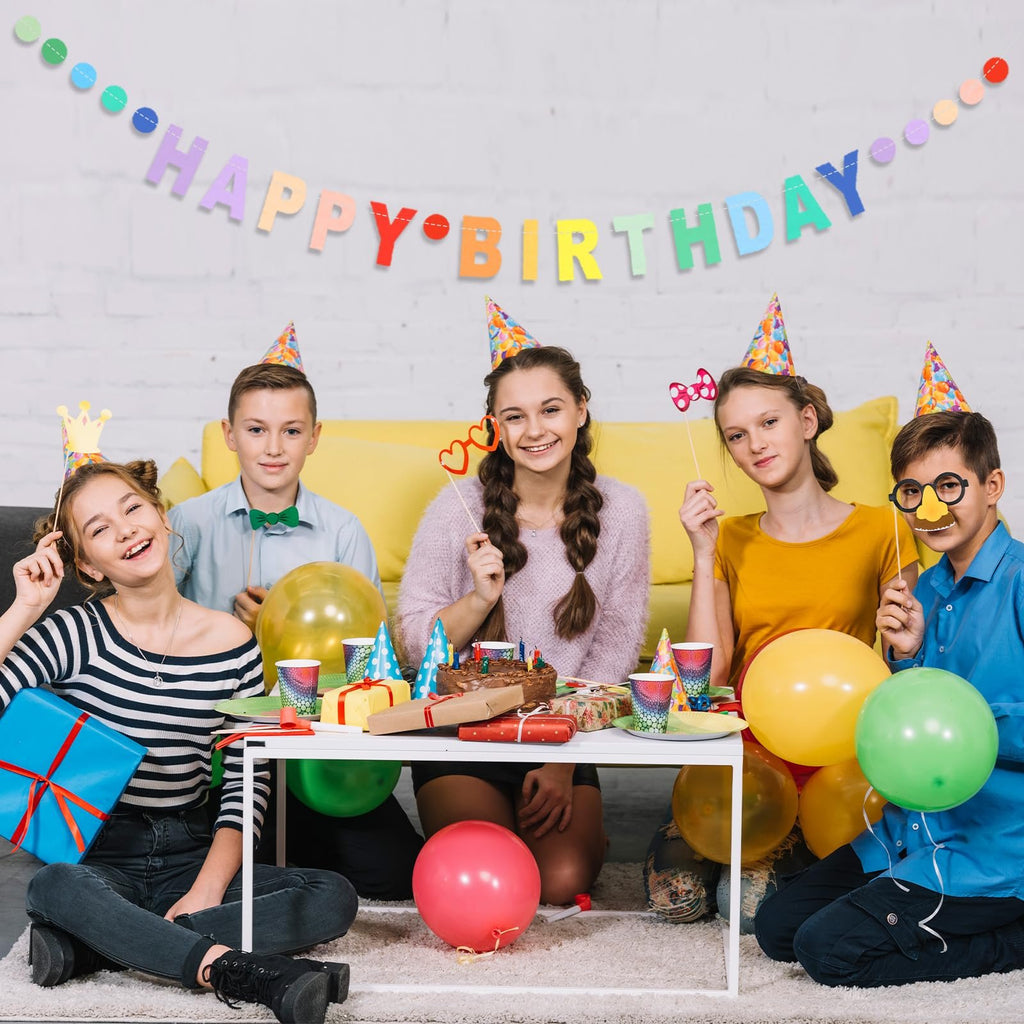 Five children celebrating a birthday party around a table with a cake and presents.