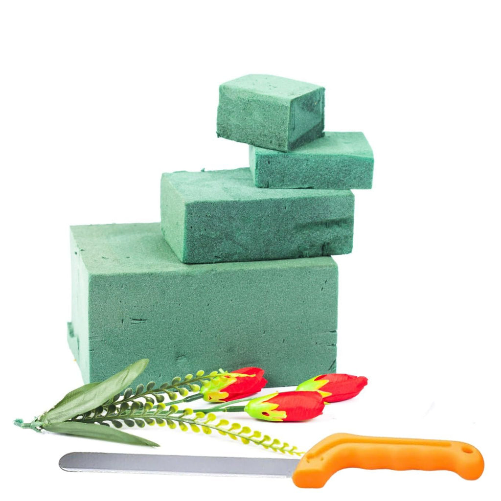 Floral foam blocks stacked with artificial tulips and a floral knife on a white background