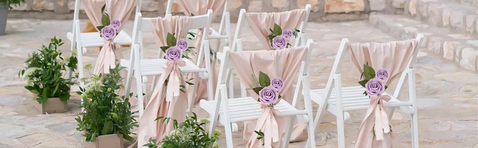 Wedding ceremony chairs decorated with purple roses and pink sashes, with greenery in foreground.